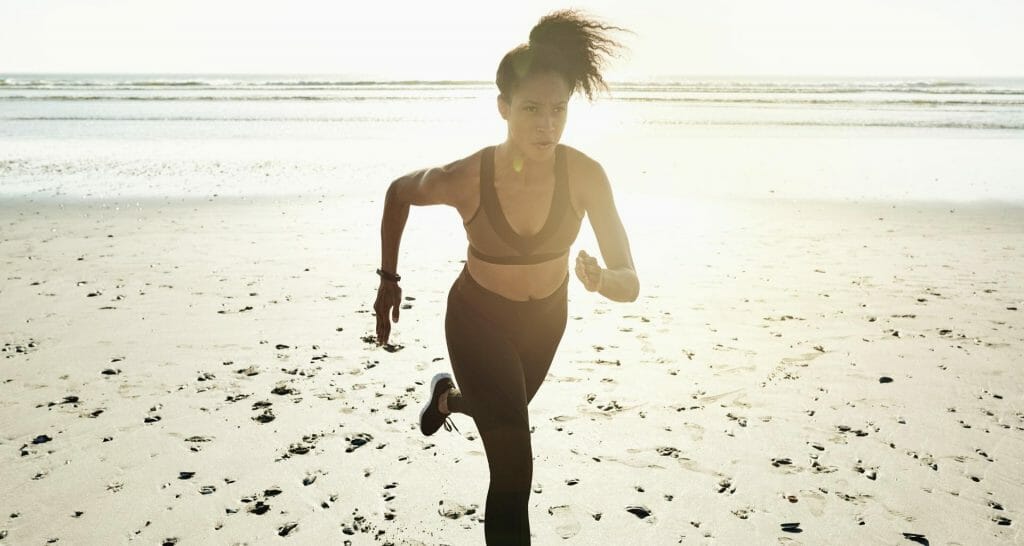träning kvinna springer strand