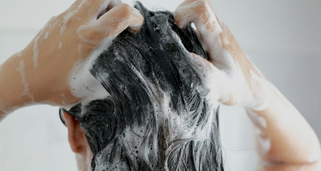 Kvinna schamponerar håret
