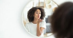Kvinna som luftpussar sin spegelbild