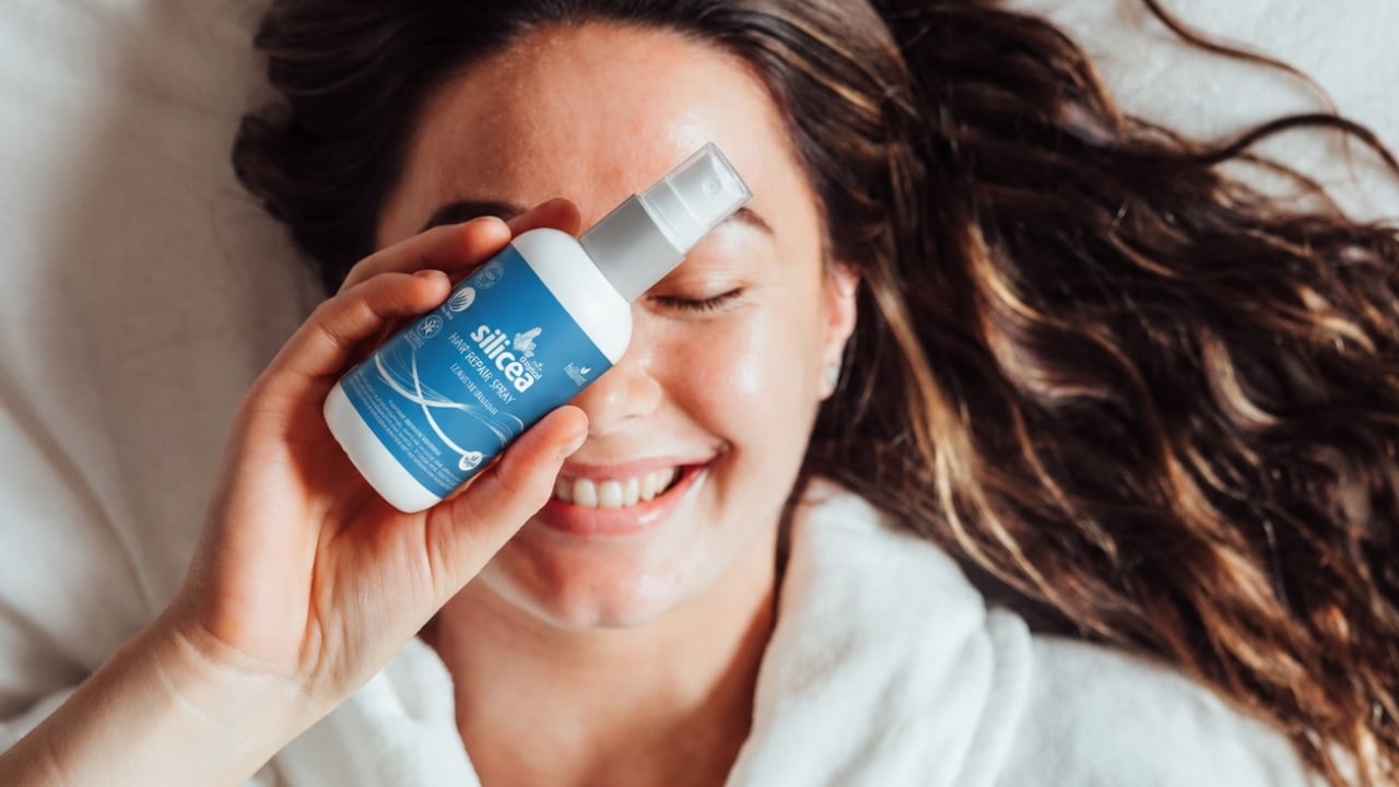 Kvinna med Silicea Hair Repair Balsam Spray vid håret