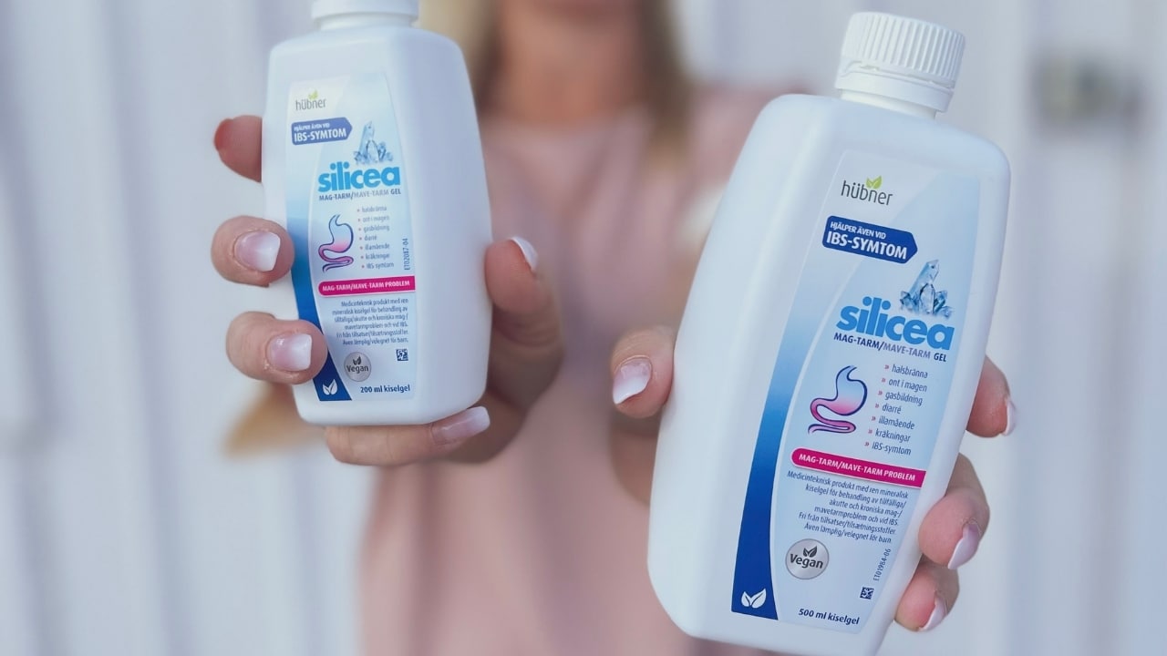 Person visar Silicea Mag-Tarm gel i 200 ml och 500 ml flaskor